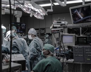 Healthcare technology behind doctors doing a procedure in an operating room.
