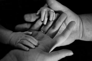 A child's hands grasping adult hands.