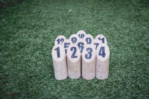 Twelve numbered pins set up on a lawn for a outdoor bowling game.